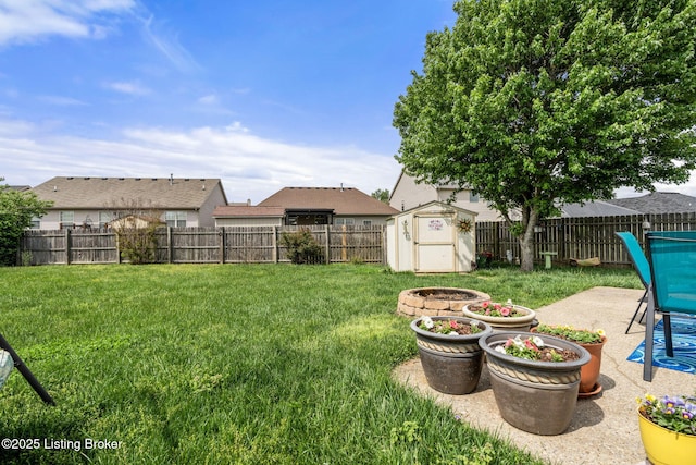 view of yard with a fenced backyard, an outbuilding, a shed, and a patio