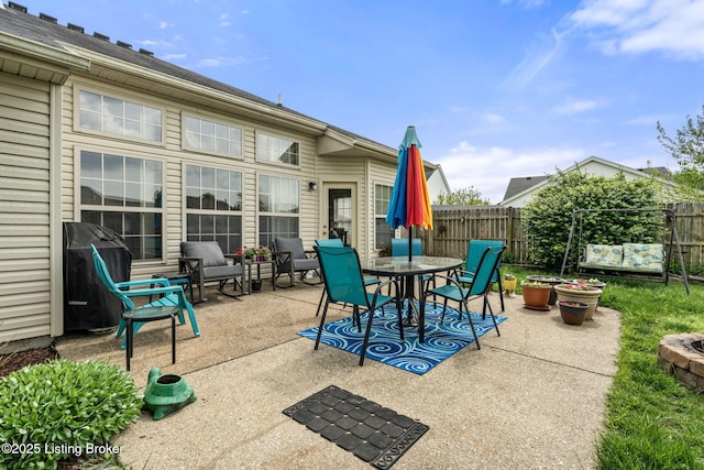 view of patio with outdoor dining space, fence, and area for grilling