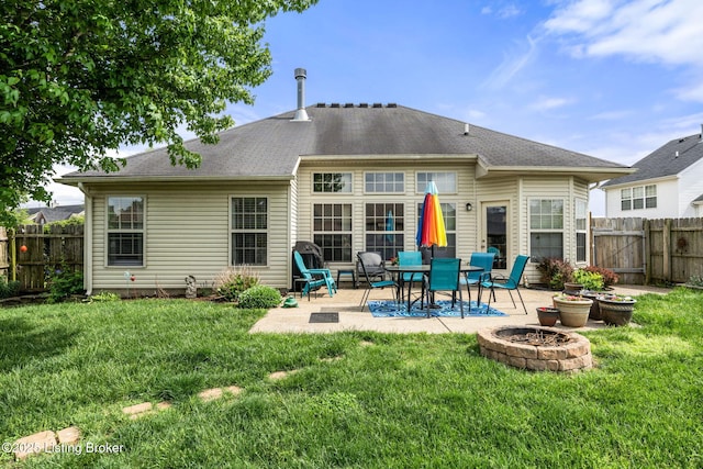 rear view of house with a fenced backyard, a yard, an outdoor fire pit, and a patio area