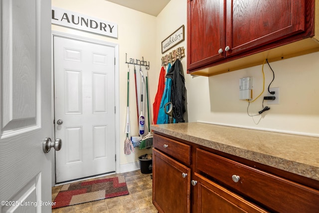 clothes washing area featuring baseboards