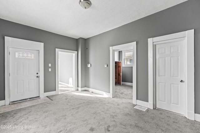 interior space featuring carpet floors, baseboards, and visible vents