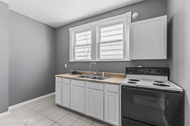 kitchen featuring range with electric cooktop, a sink, baseboards, white cabinets, and light tile patterned floors