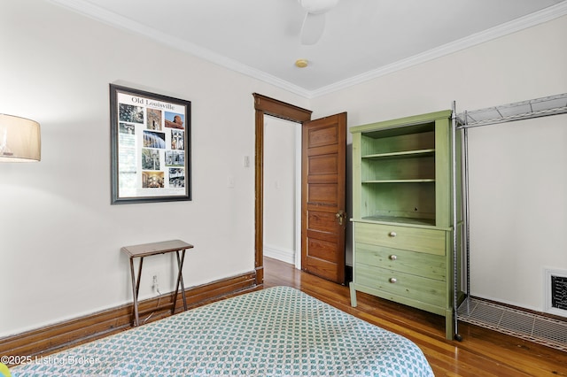 bedroom with dark wood-style flooring, ornamental molding, and a ceiling fan