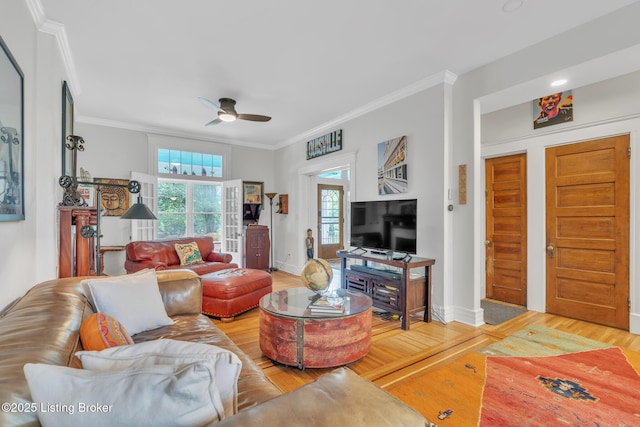 living room with wood finished floors, ceiling fan, ornamental molding, and baseboards