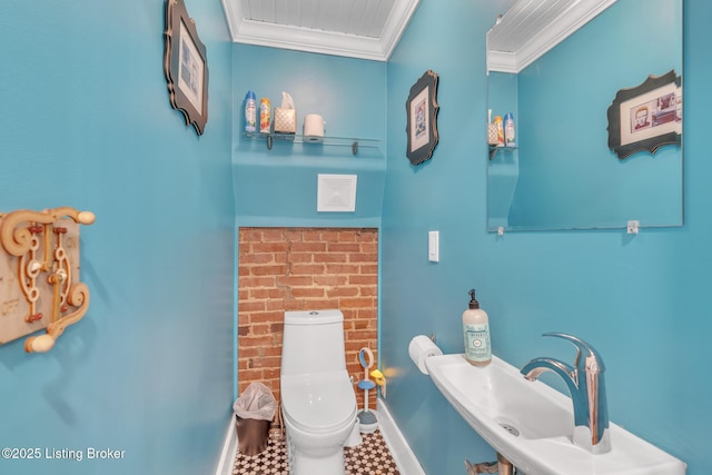 half bathroom featuring crown molding, toilet, baseboards, and a sink