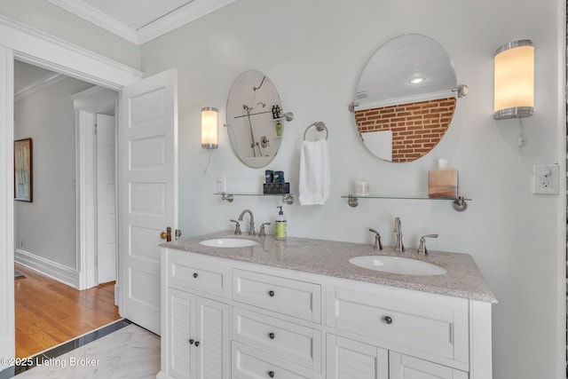 bathroom featuring ornamental molding, double vanity, and baseboards