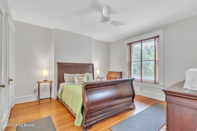 bedroom featuring light wood-type flooring, baseboards, and ceiling fan
