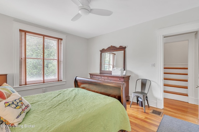 bedroom featuring light wood-style floors, a ceiling fan, and baseboards