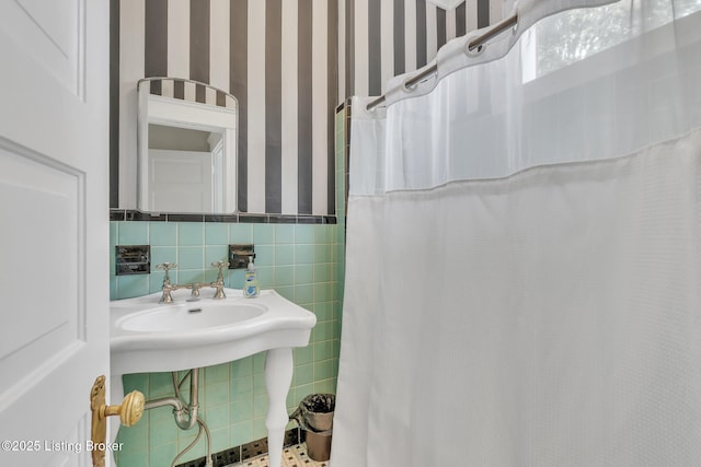 bathroom featuring tile walls, wainscoting, and a shower with shower curtain