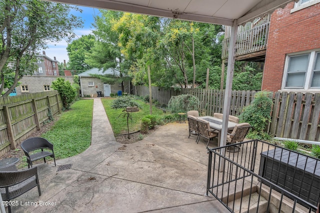 view of patio featuring outdoor dining space and an outbuilding