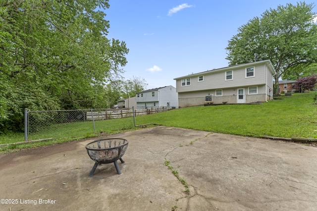 back of house featuring a patio, a fire pit, fence, and a yard