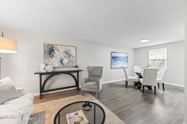 living area with baseboards and wood finished floors