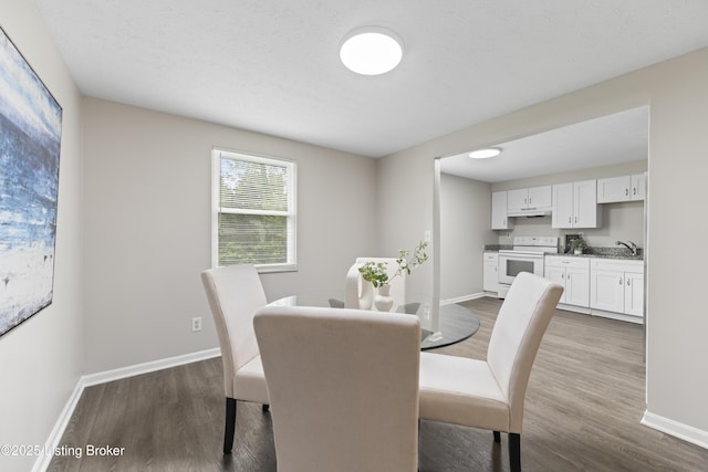 dining area featuring dark wood-type flooring and baseboards