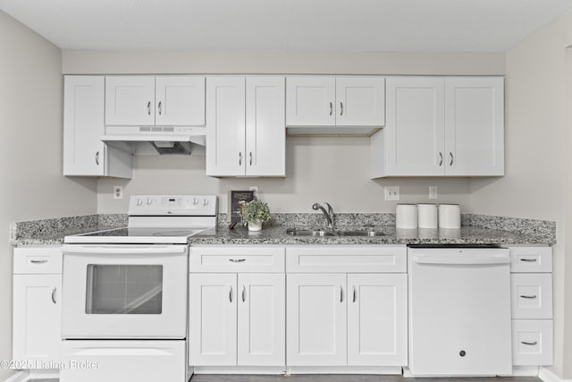 kitchen with white appliances, stone countertops, under cabinet range hood, white cabinets, and a sink