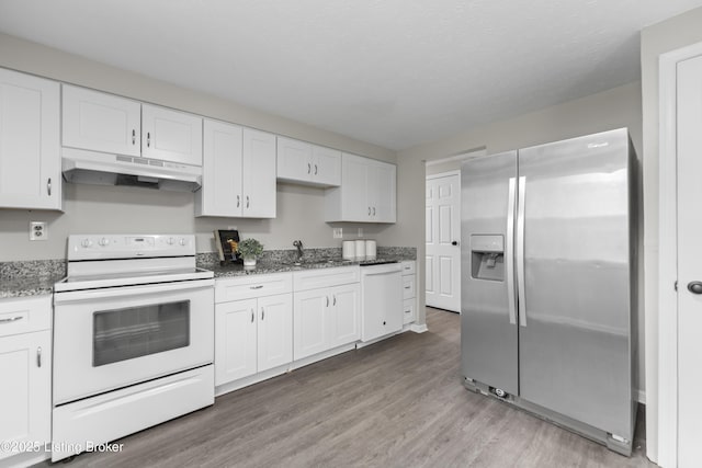 kitchen featuring a sink, light wood finished floors, under cabinet range hood, white appliances, and white cabinetry