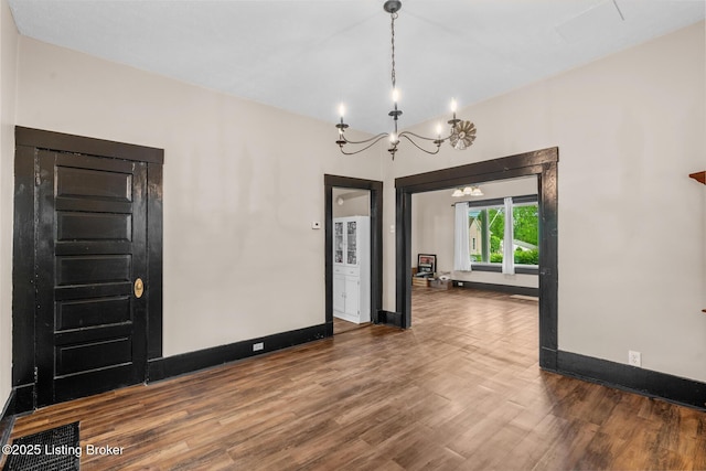 717 Highland Ave, Carrollton, KY 41008 - empty room featuring baseboards, a chandelier, and wood finished floors