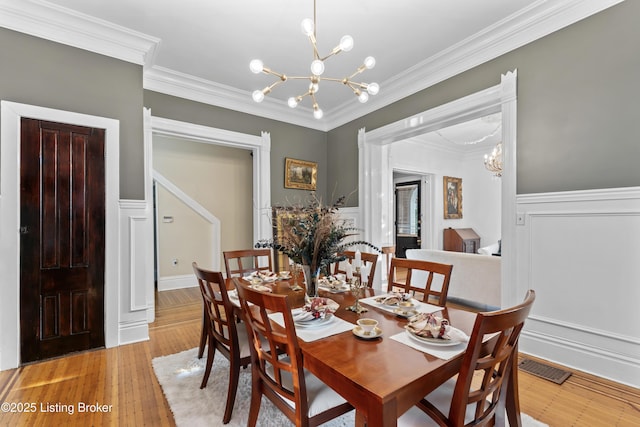 1332 S 2nd St, Louisville, KY 40208 - dining area with an inviting chandelier, wainscoting, a decorative wall, visible vents, and ornamental molding