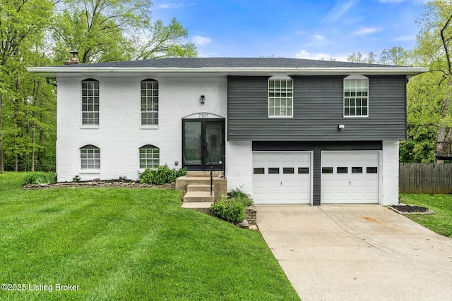 bi-level home with brick siding, an attached garage, and concrete driveway
