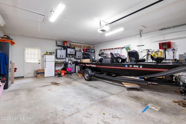 7411 Colt Dr, Louisville, KY 40214 - garage with a garage door opener and freestanding refrigerator