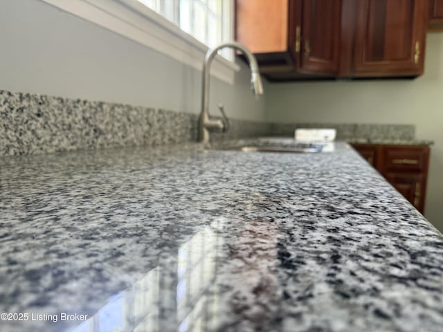 kitchen with a sink and light stone countertops