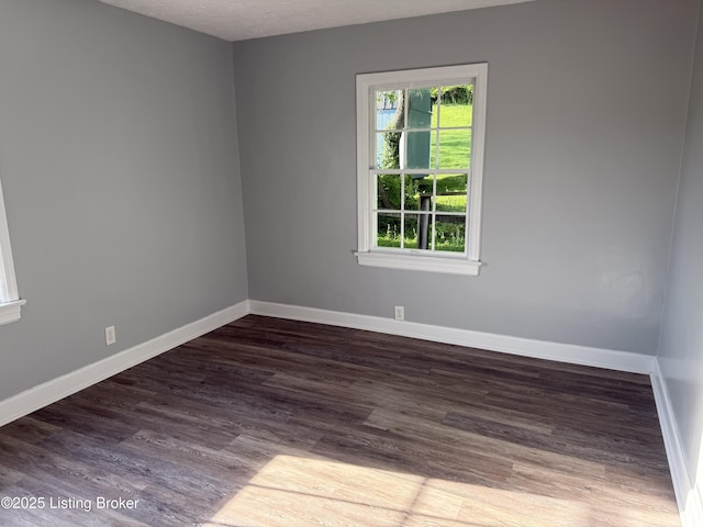 empty room featuring baseboards and wood finished floors