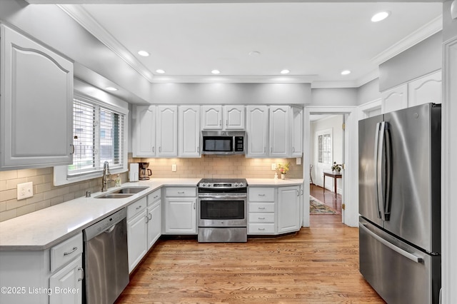 2335 Bonnycastle Ave, Louisville, KY 40205 - kitchen with appliances with stainless steel finishes, a sink, plenty of natural light, ornamental molding, and light wood-style flooring