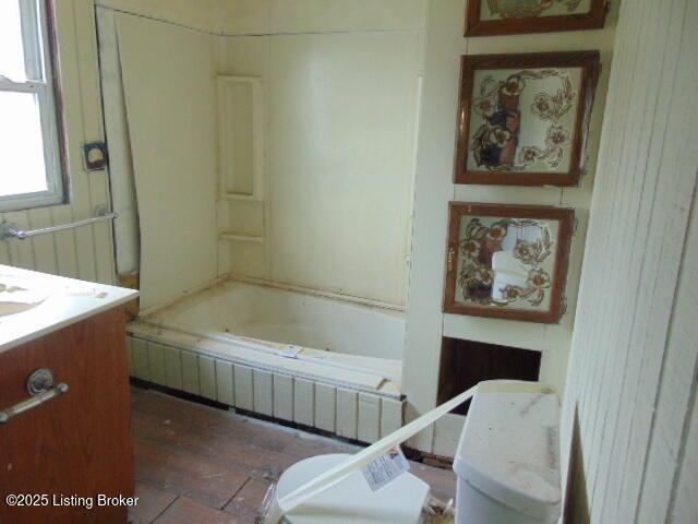 full bath featuring toilet, wood finished floors, and vanity
