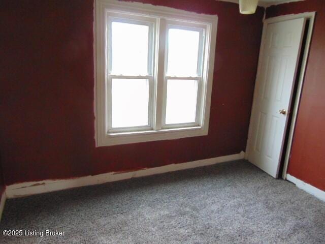 carpeted spare room with a wealth of natural light and baseboards