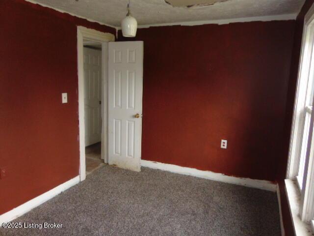 unfurnished room featuring baseboards and carpet floors
