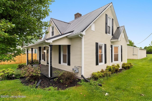 209 W High St, Lebanon, KY 40033 - view of side of home with covered porch, a chimney, a lawn, metal roof, and a standing seam roof