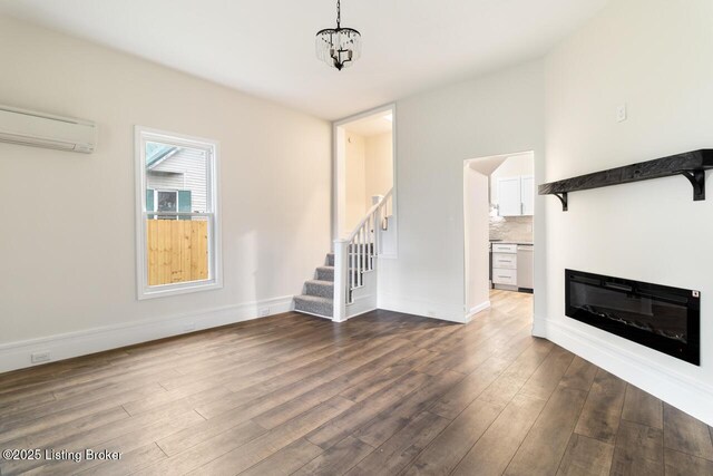 209 W High St, Lebanon, KY 40033 - unfurnished living room with a wall unit AC, baseboards, dark wood-style flooring, a glass covered fireplace, and stairway