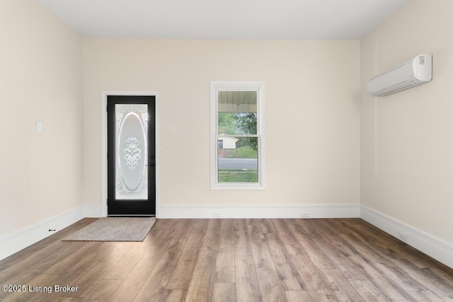 209 W High St, Lebanon, KY 40033 - foyer with an AC wall unit, baseboards, and wood finished floors