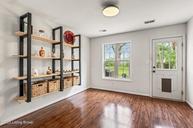 doorway to outside with wood finished floors and baseboards
