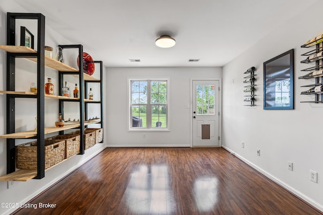 doorway featuring wood finished floors and baseboards