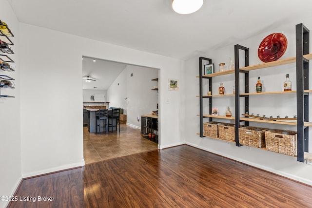 interior space featuring dark wood finished floors, baseboards, and ceiling fan
