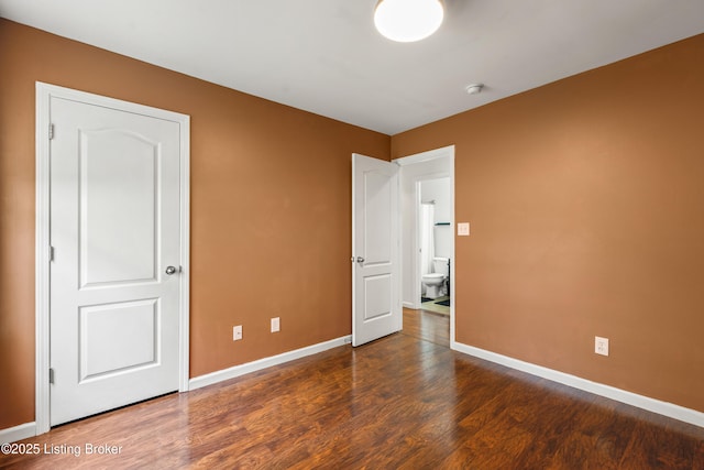 unfurnished bedroom featuring wood finished floors and baseboards
