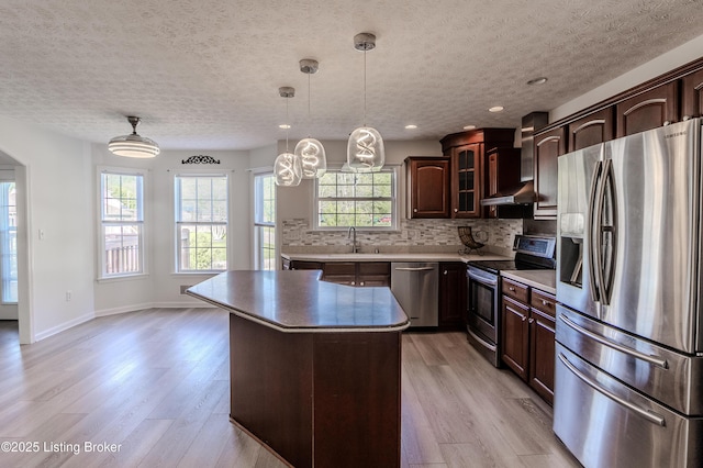 5503 Vevia Pl, Louisville, KY 40272 - kitchen with appliances with stainless steel finishes, wall chimney exhaust hood, a textured ceiling, light wood finished floors, and a sink