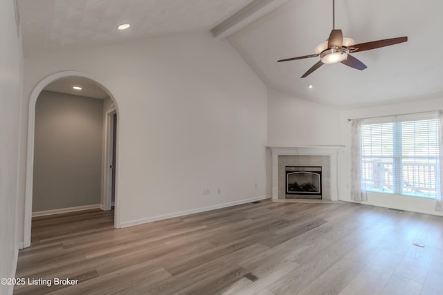 5503 Vevia Pl, Louisville, KY 40272 - unfurnished living room with light wood-style flooring, a tiled fireplace, ceiling fan, arched walkways, and recessed lighting