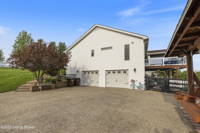 view of home's exterior with a garage, a yard, and driveway