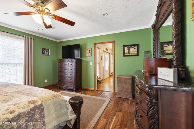 bedroom featuring dark wood-type flooring, ornamental molding, baseboards, and a ceiling fan