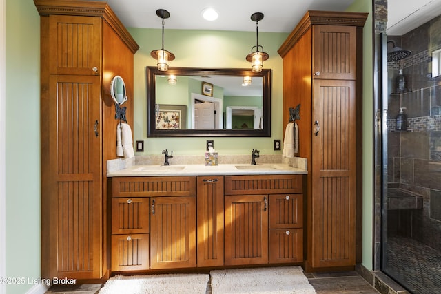 full bathroom with double vanity, a tile shower, and a sink