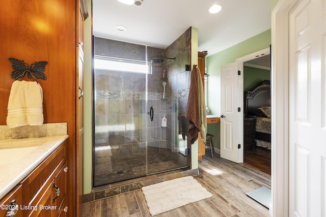 bathroom with vanity, recessed lighting, wood finished floors, and a stall shower