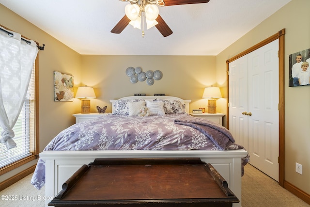 bedroom featuring a ceiling fan, baseboards, light carpet, and a closet