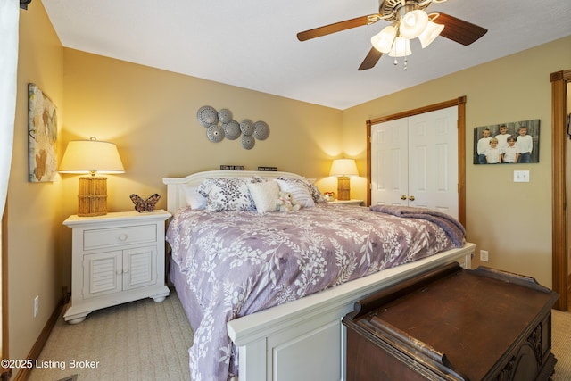 bedroom featuring a ceiling fan, baseboards, light carpet, and a closet