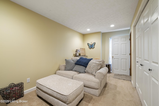 living area with light colored carpet, recessed lighting, a textured ceiling, and baseboards