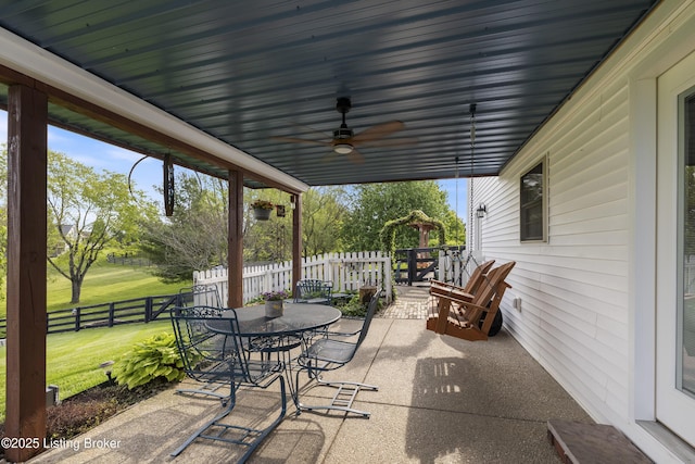 view of patio featuring a ceiling fan, fence, and outdoor dining space