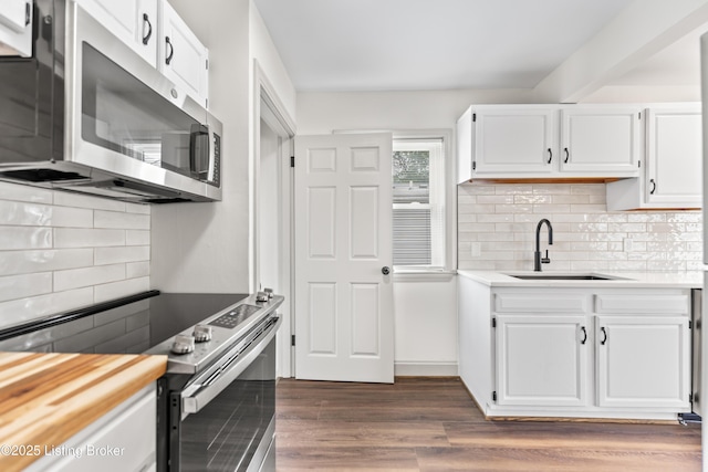 kitchen featuring decorative backsplash, appliances with stainless steel finishes, a sink, light countertops, and white cabinets