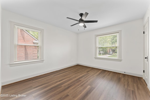 unfurnished bedroom with baseboards, multiple windows, and wood finished floors