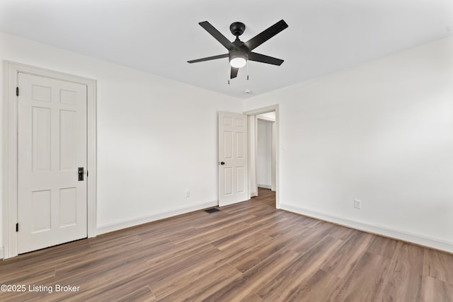 unfurnished bedroom with baseboards, ceiling fan, wood finished floors, and visible vents