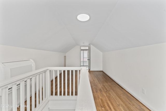 bonus room featuring vaulted ceiling and wood finished floors